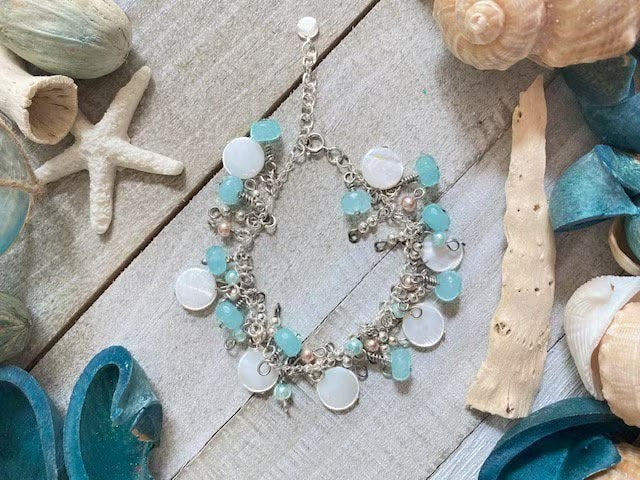 Sand and Sea handmade beach charm bracelet with white lentil shells, turquoise rondelles, and sterling silver.