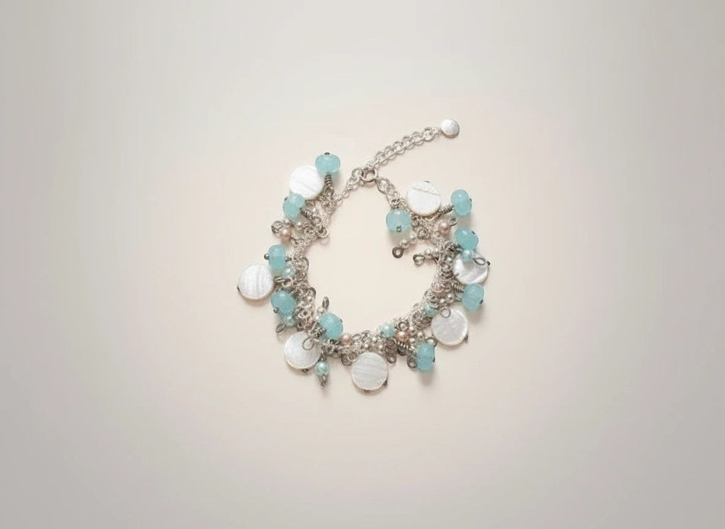 Sand and Sea handmade beach-inspired charm bracelet with white lentil shells, turquoise rondelles, and pearl beads.