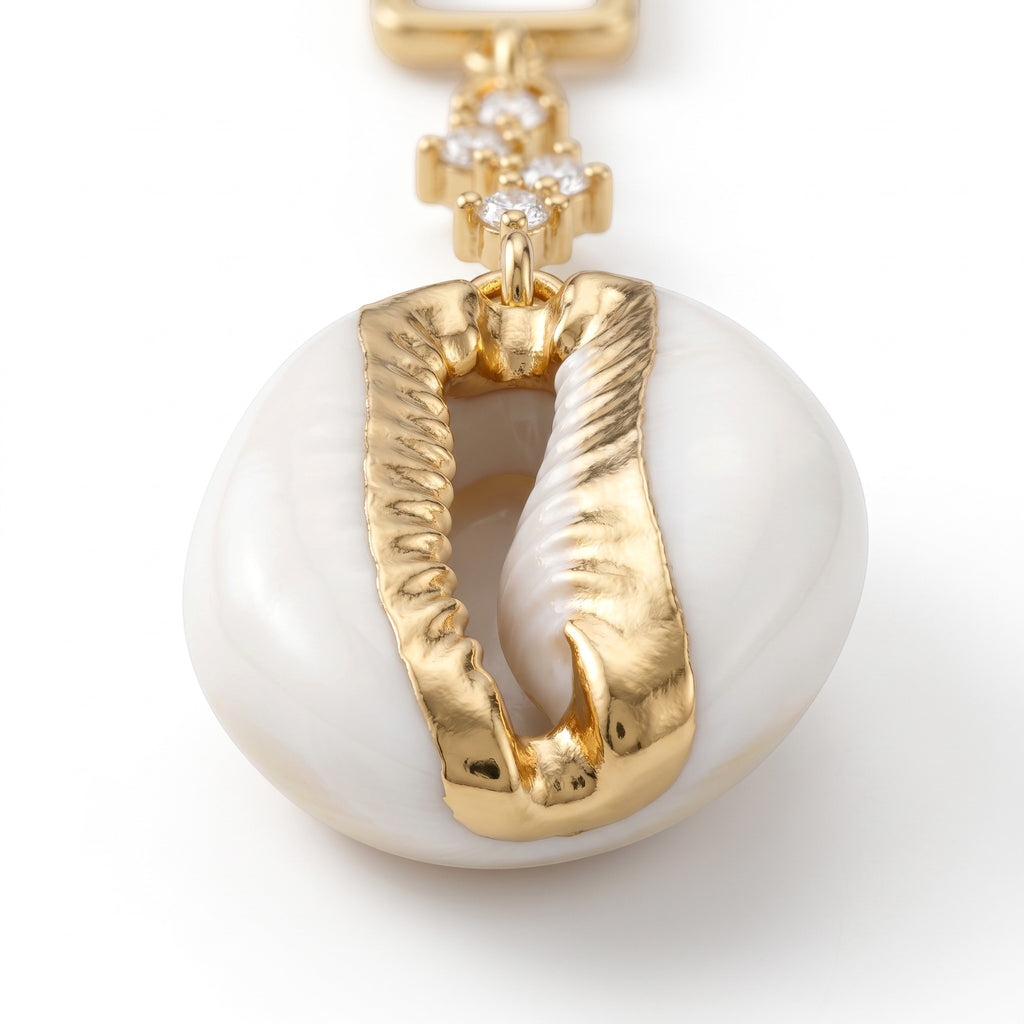 Sand and Sea gold-tone dangle earrings with white cowrie shell and cubic zirconia stud.