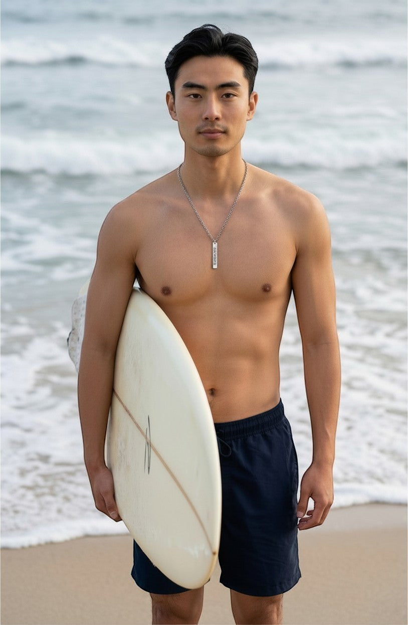 Sand and Sea Engraved Silver Apobangpo Vertical Bar Necklace on a man at the beach