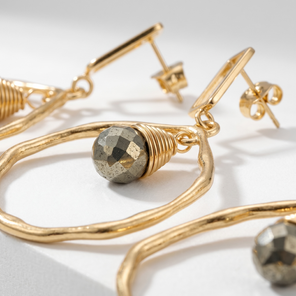 Sand and Sea gold-tone geometric drop earrings with faceted pyrite stone accent and textured hoop.