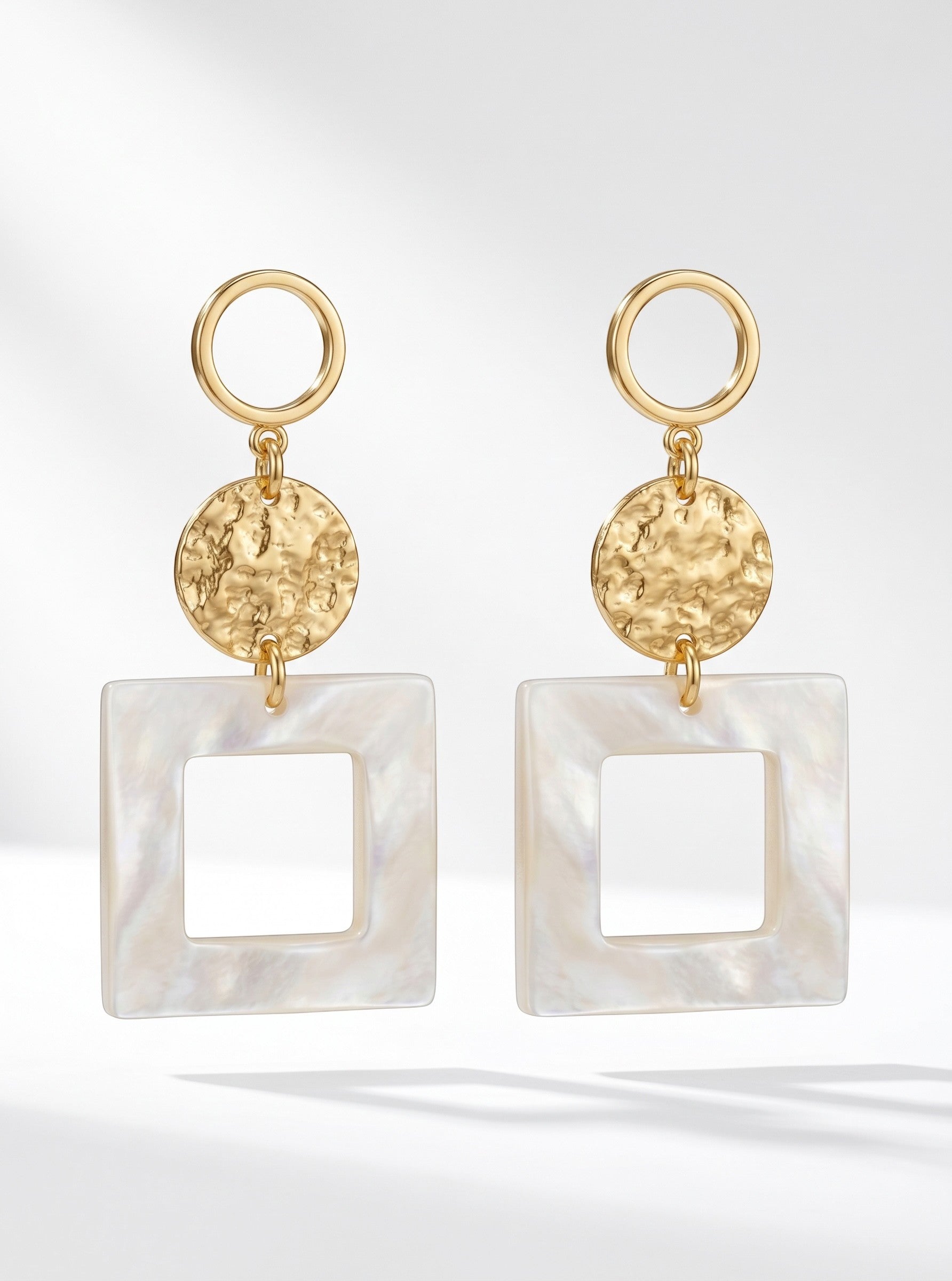 Sand and Sea geometric drop earrings with gold-tone hammered discs and white square frames.