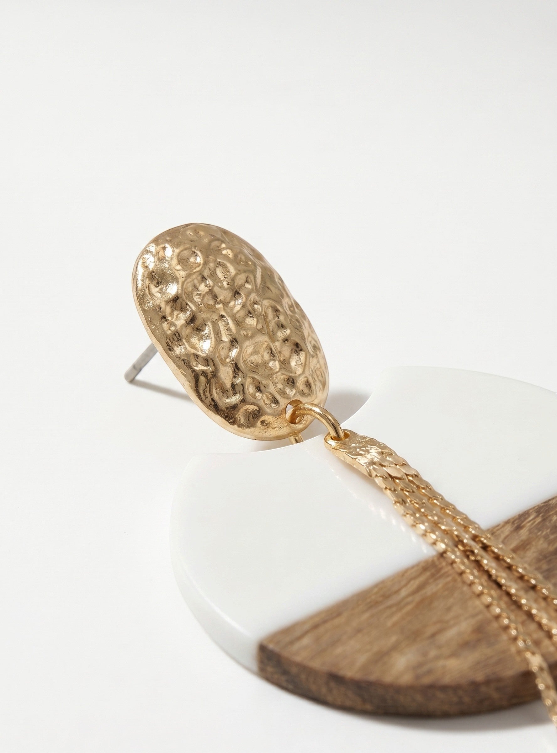 Sand and Sea geometric drop earrings with hammered gold top, white inlay, and gold chain tassels.