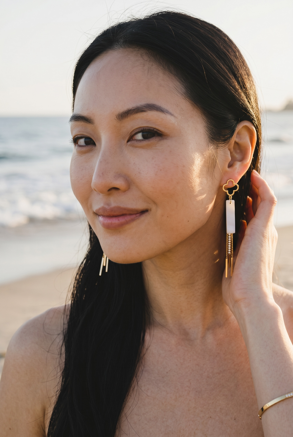 Sand and Sea gold clover dangle earrings with white stone inlay and crystal chain accents