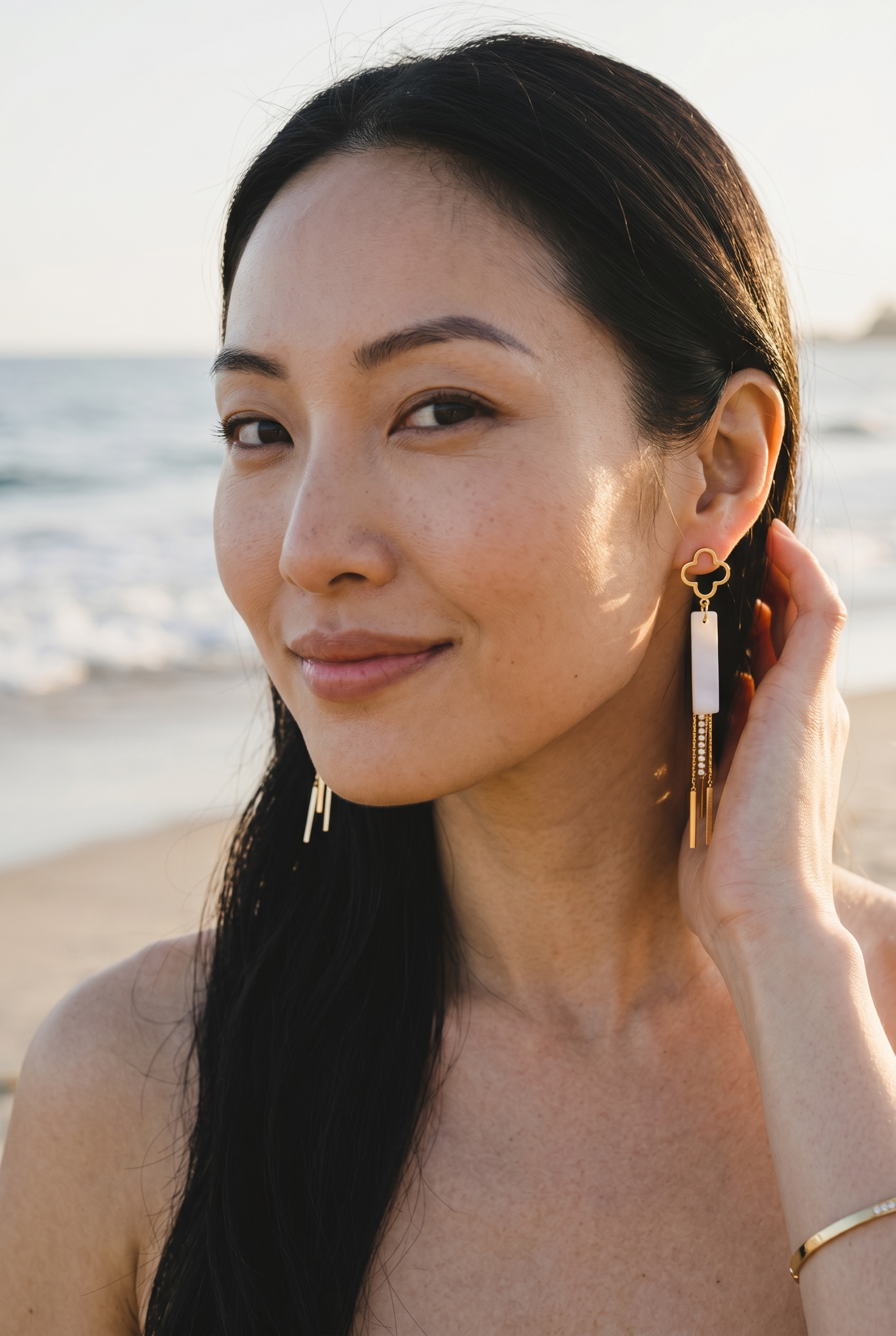 Sand and Sea gold clover dangle earrings with white stone inlay and crystal chain accents