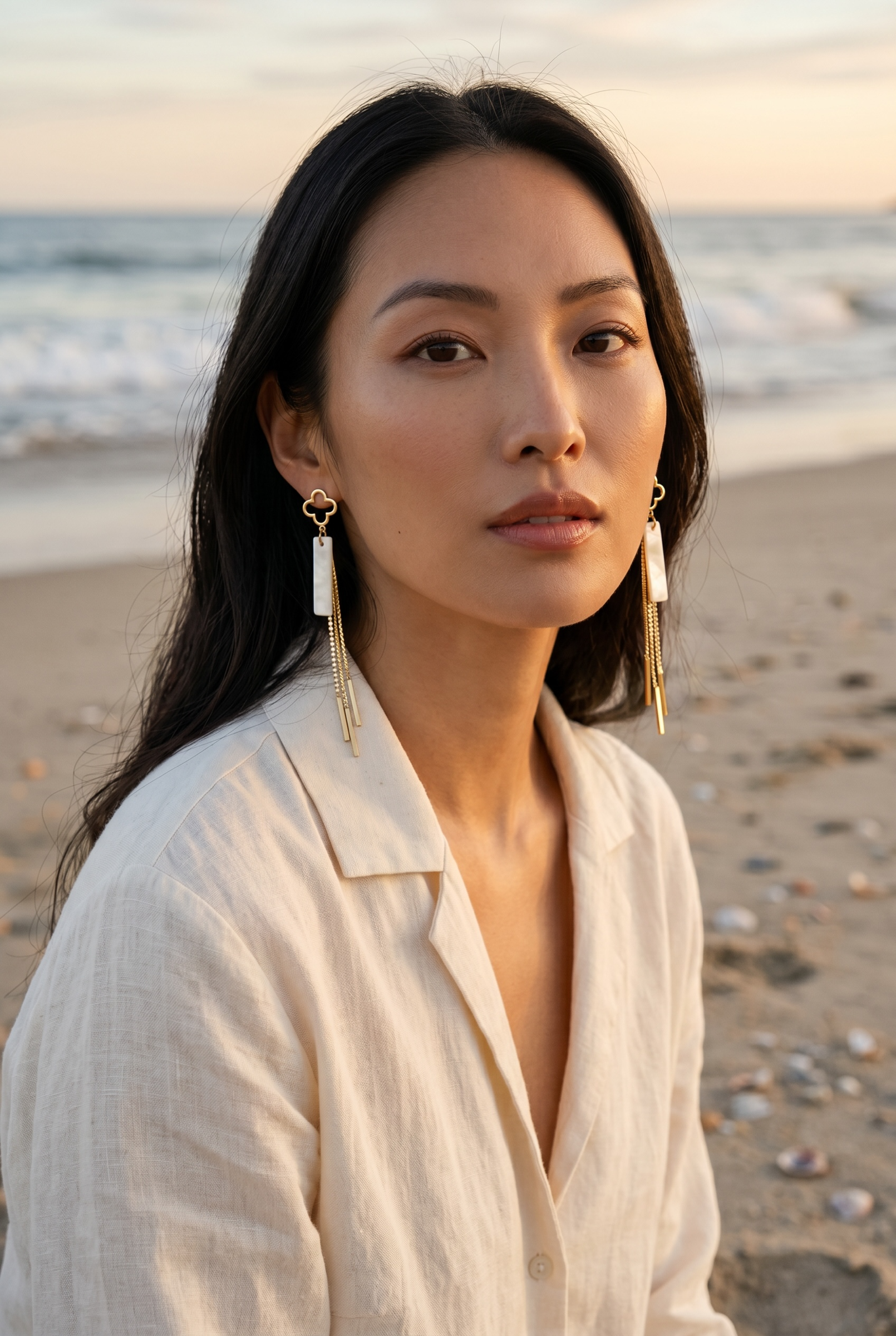 Sand and Sea gold clover dangle earrings with white stone inlay and crystal chain details.