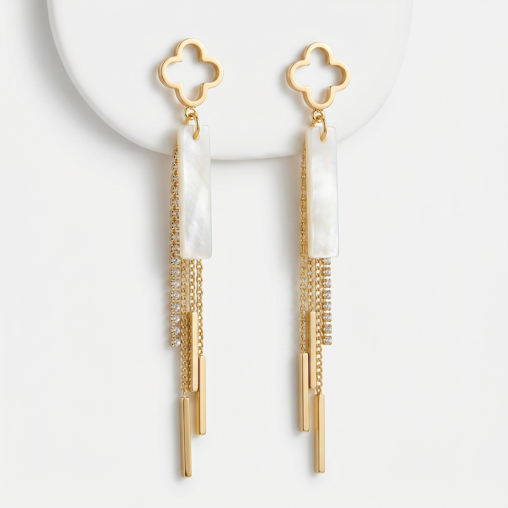 Sand and Sea gold clover dangle earrings with white stone inlay and crystal chain tassels.