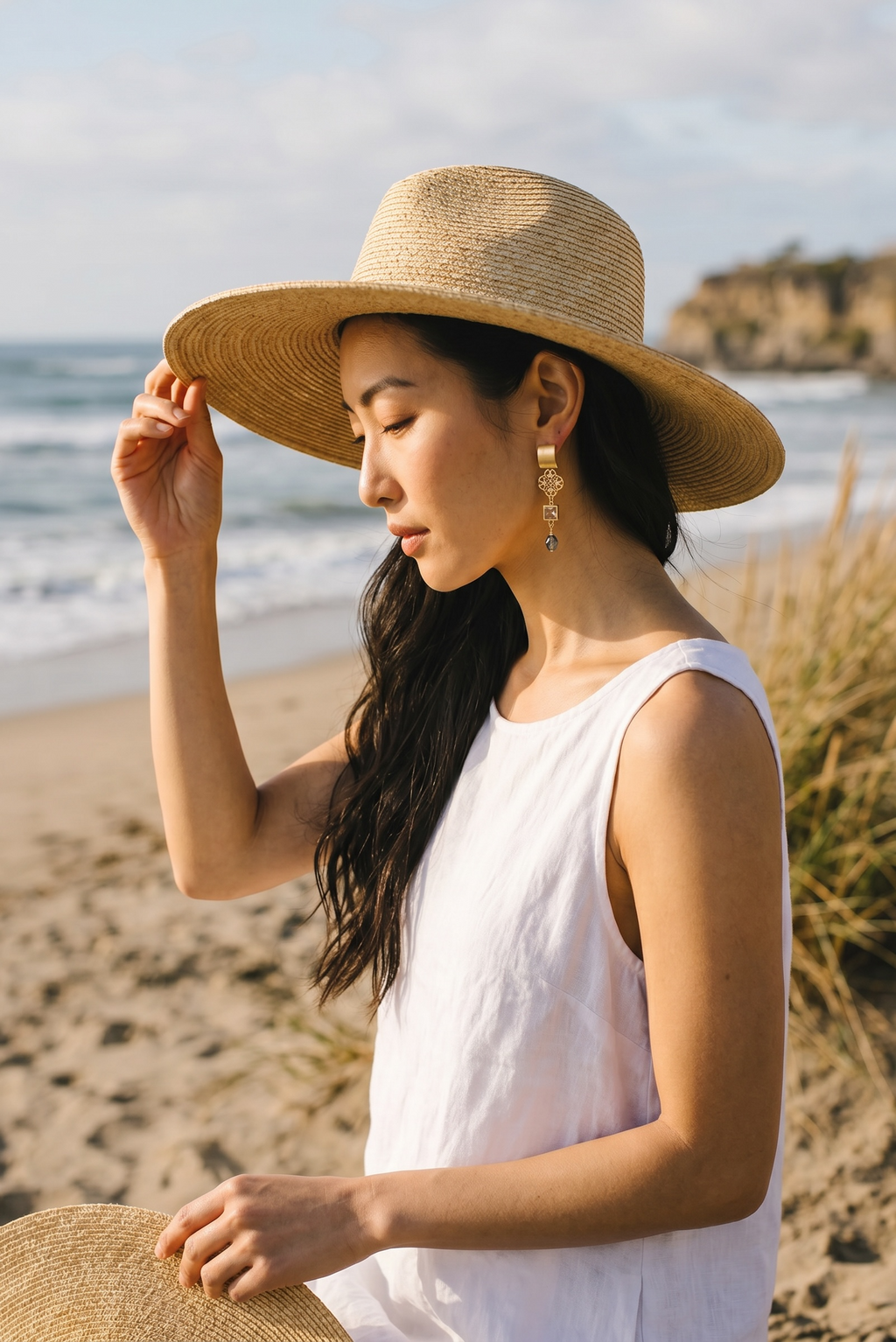 Sand and Sea gold-plated dangle earrings with blue-green teardrop bead and cubic zirconia accent.