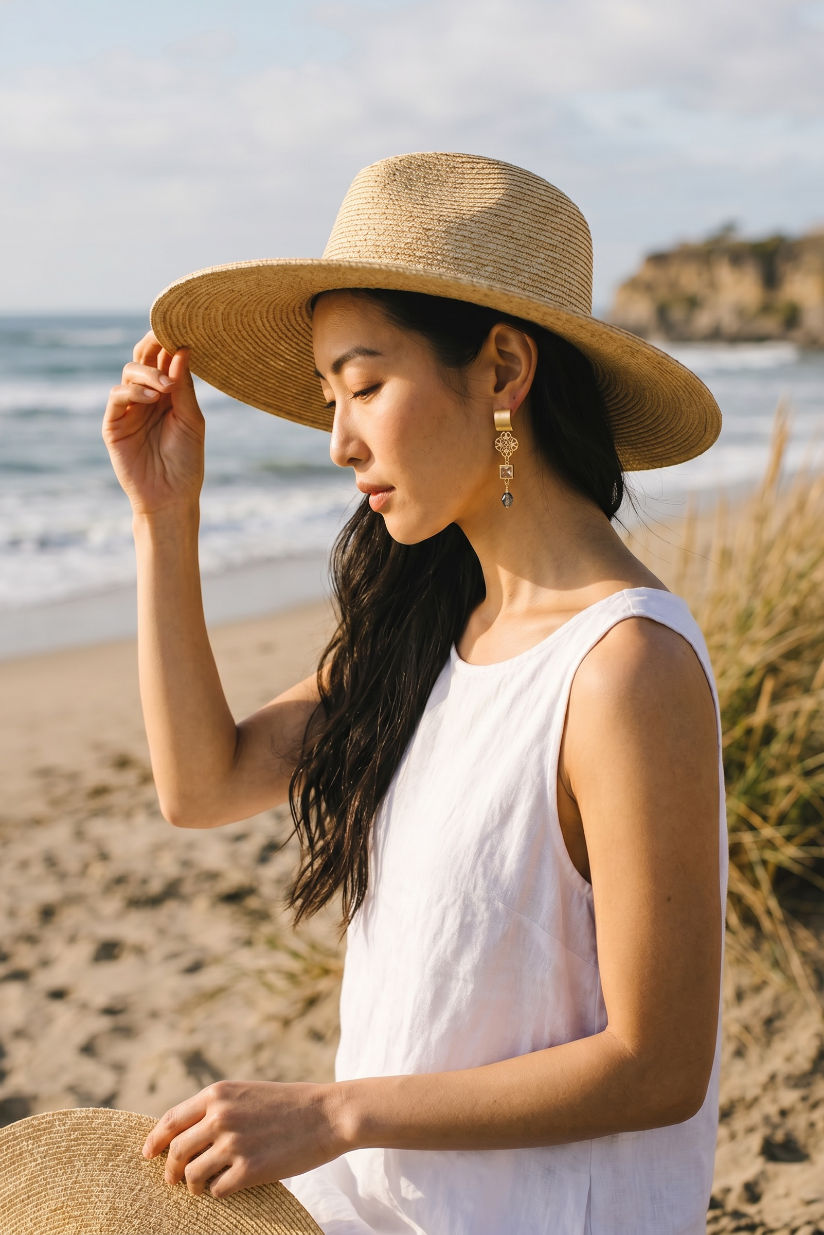 Sand and Sea gold-plated dangle earrings with blue-green teardrop bead and cubic zirconia accent.