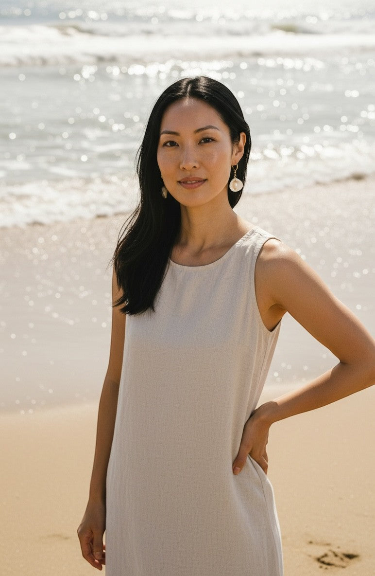 Sand and Sea 18k gold dangle earrings with freshwater pearls and white shell accents. Coastal charm.