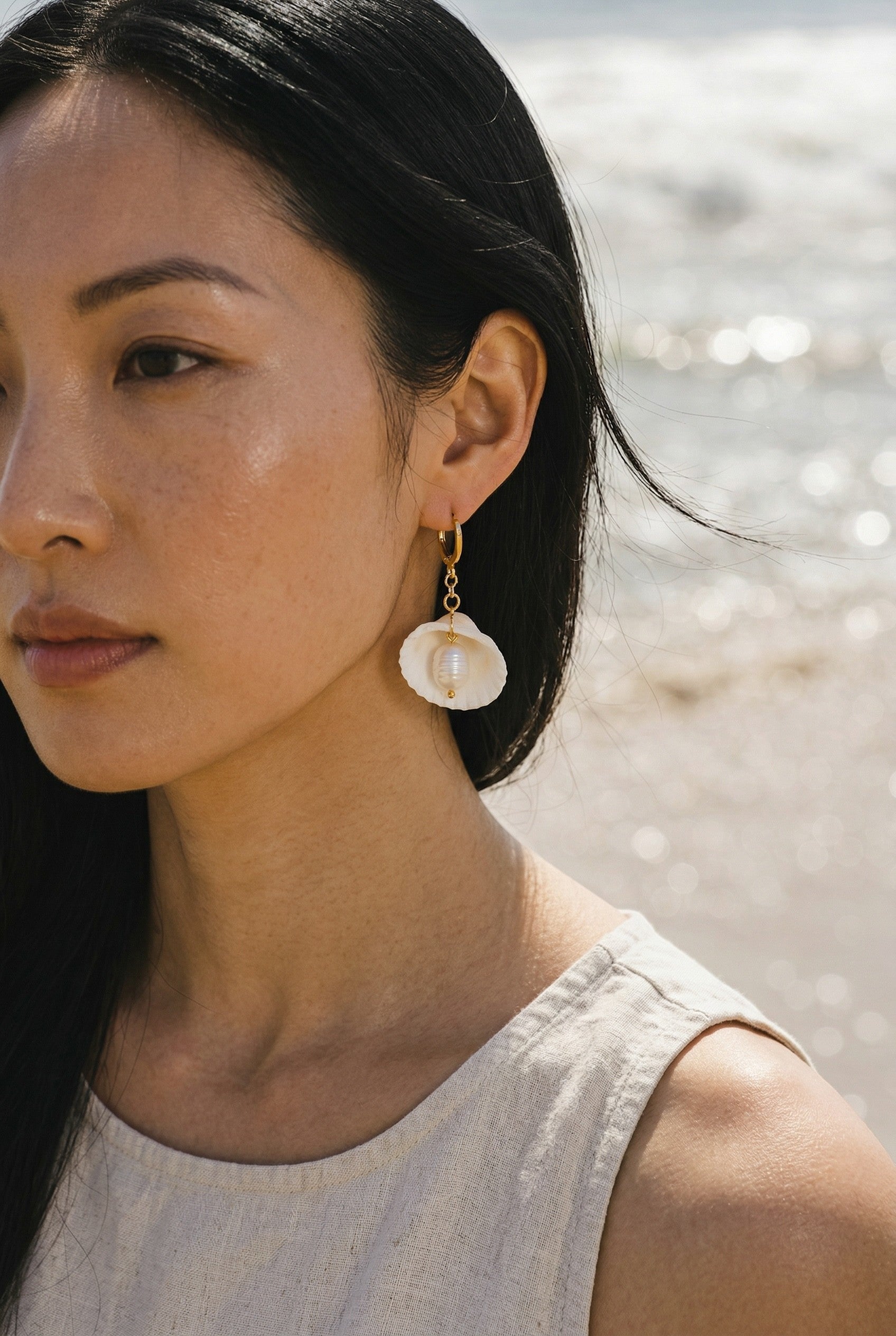Sand and Sea 18k gold dangle earrings with white shell and pearl accents, 1.5 inches long.