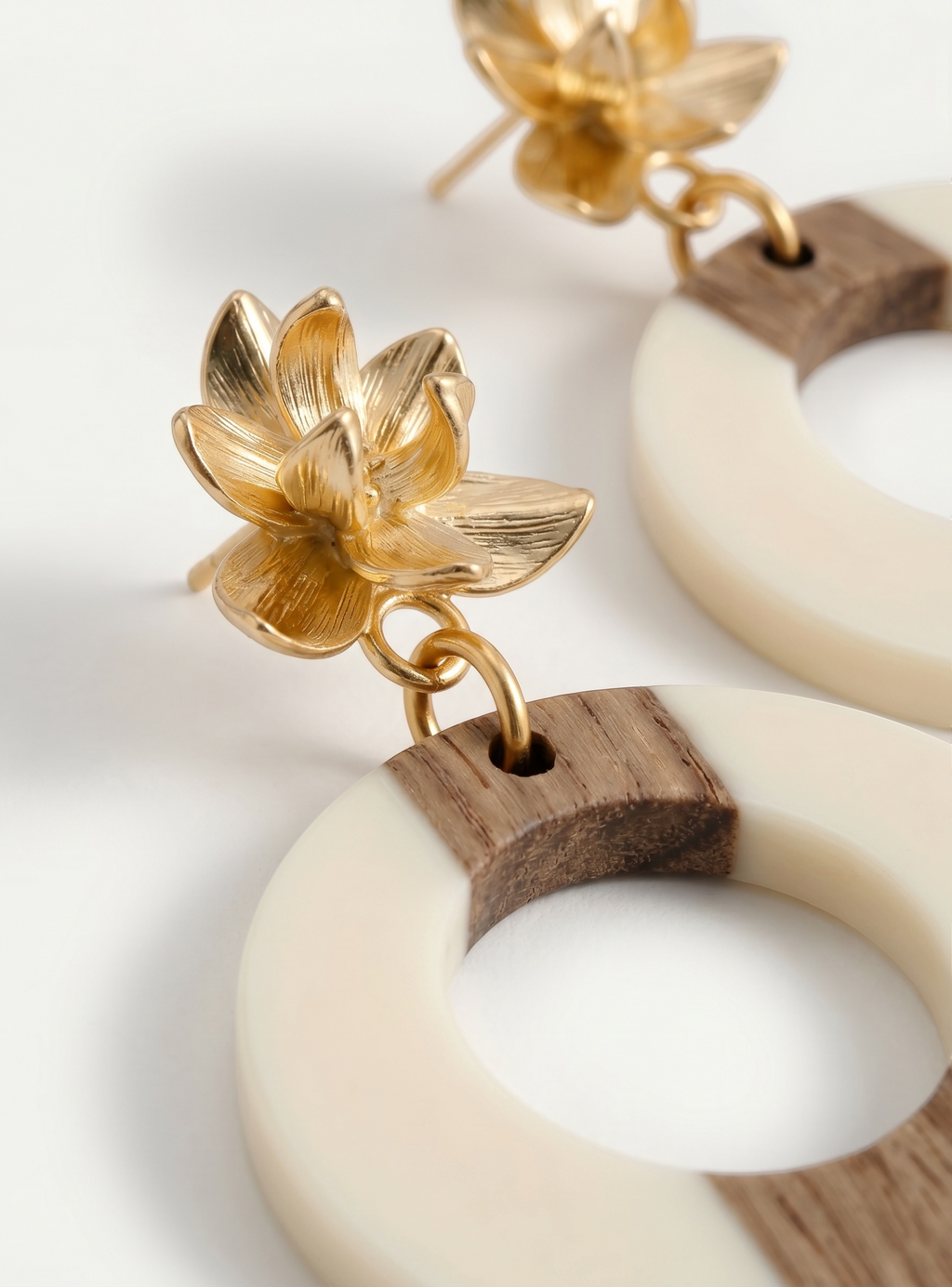 Sand and Sea statement hoop earrings with gold floral stud, wood, and cream accents. Coastal boho style.