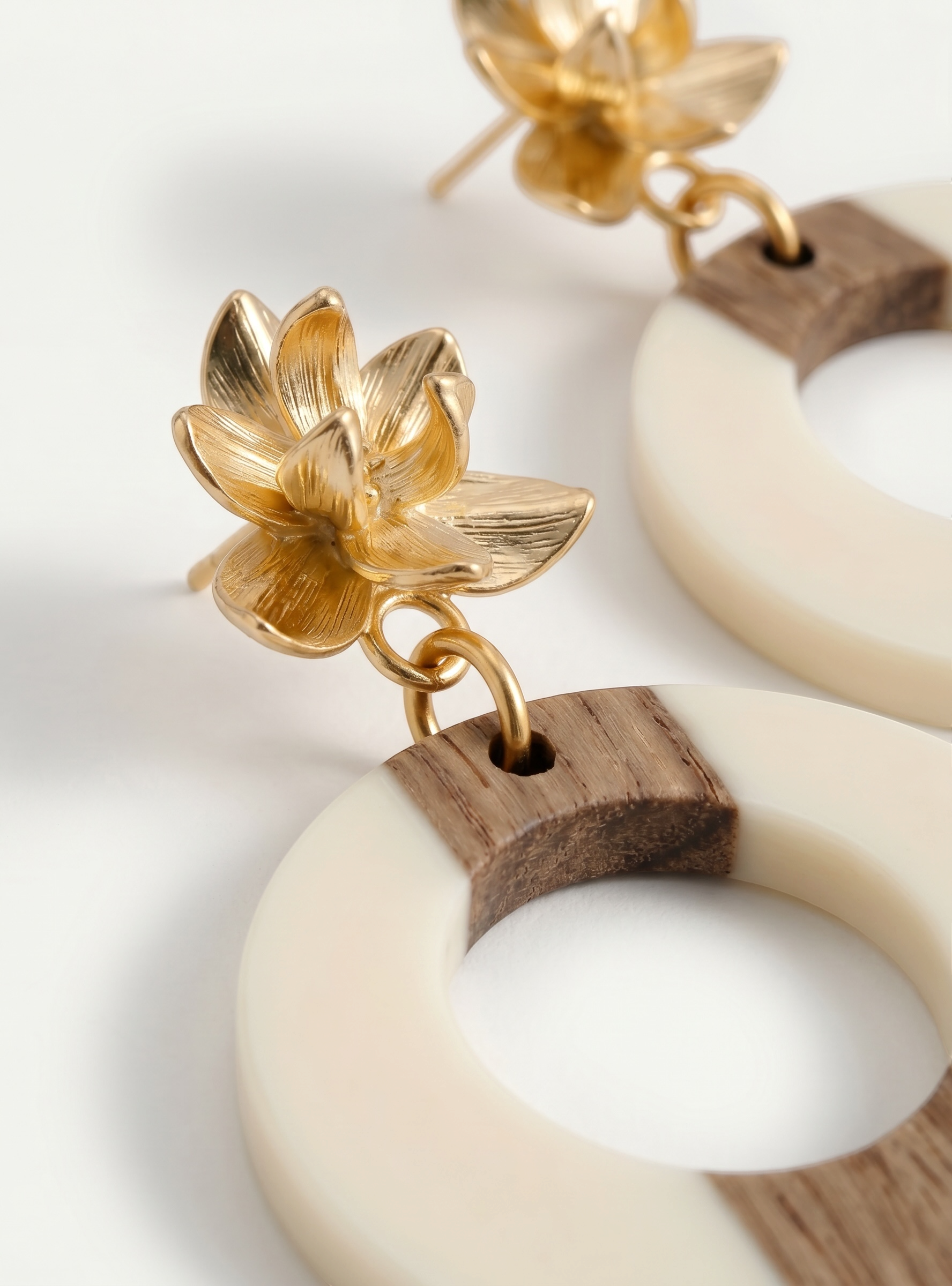 Sand and Sea statement hoop earrings with gold floral stud, wood, and cream accents. Coastal boho style.