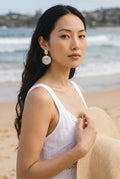 Sand and Sea round disc shell earrings with gold accent. Textured gold-tone metal top with iridescent shell disc.