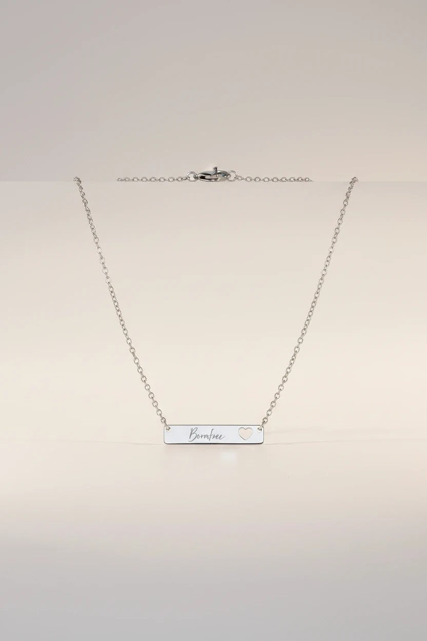 Sand and Sea silver bar necklace with cutout heart and "Borahae" engraving. Surgical-grade stainless steel.