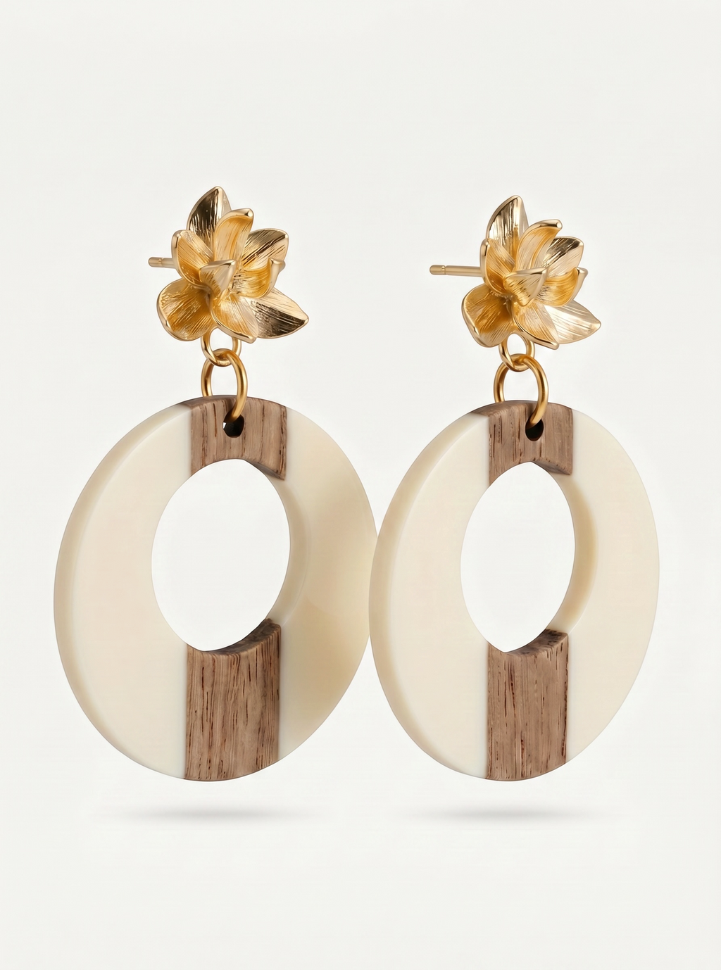 Sand and Sea statement hoop earrings with gold floral studs, featuring cream and wood-tone circles.