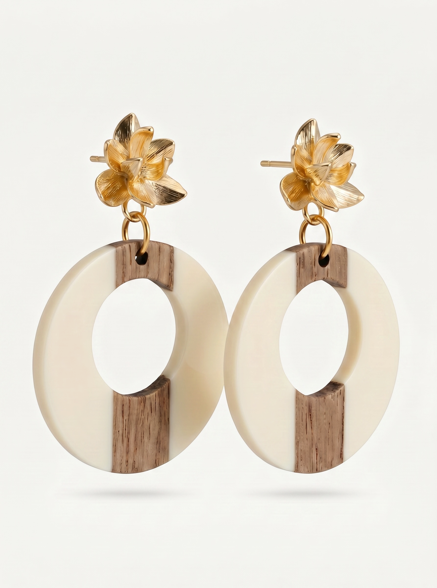 Sand and Sea statement hoop earrings with gold floral studs, featuring cream and wood-tone circles.