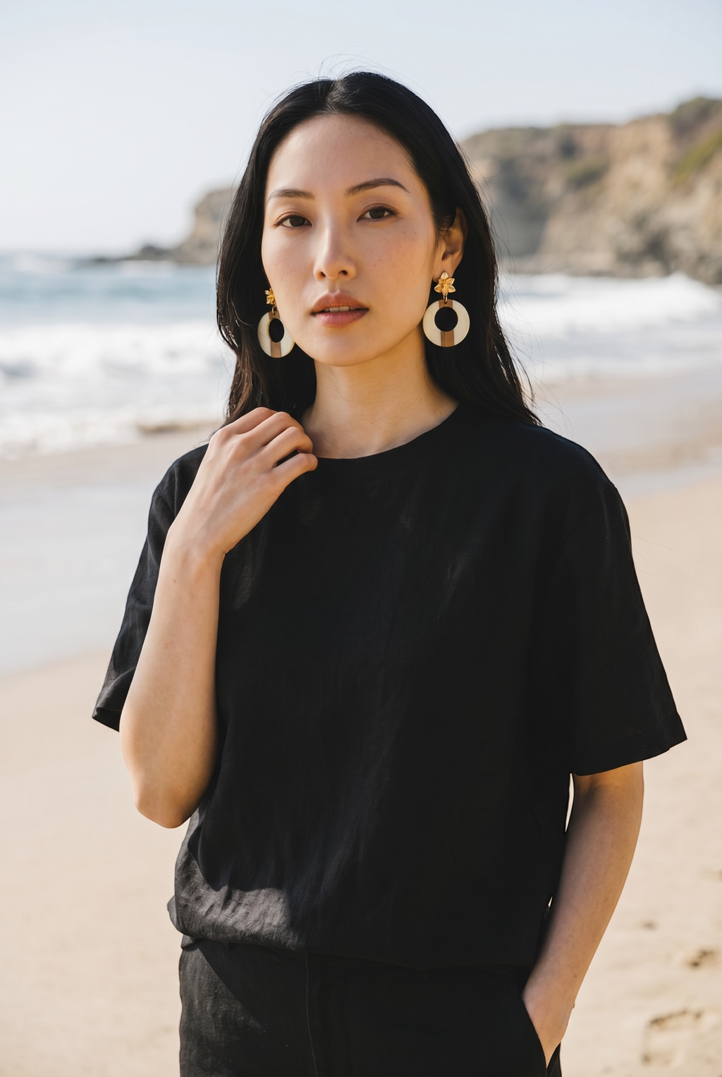 Sand and Sea statement hoop earrings with wood and white accents, featuring a floral stud. Coastal elegance.